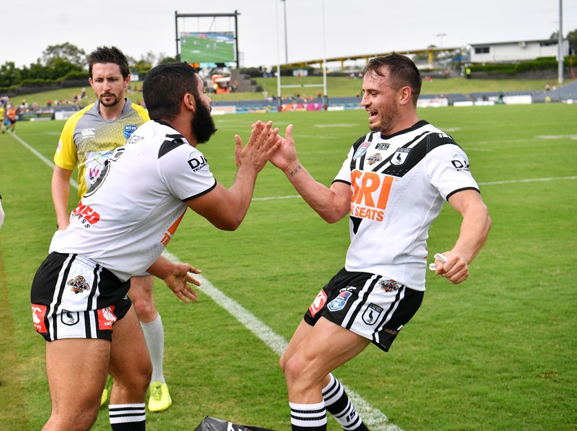 Josh Reynolds congratulates Magpies teammate Bilal Maarbani on scoring a try.