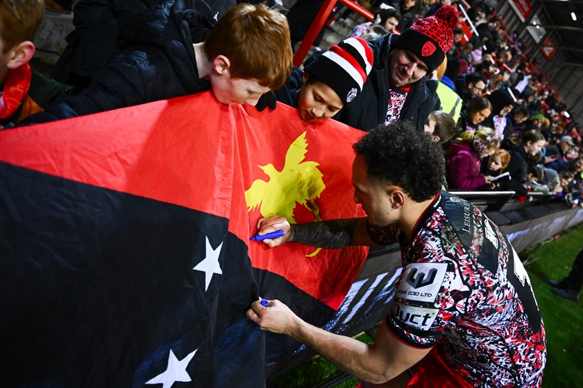 Liam Horne - one of four Kumuls who play for Leigh - signs a PNG flag at the Leopards season opening game against Leeds.
