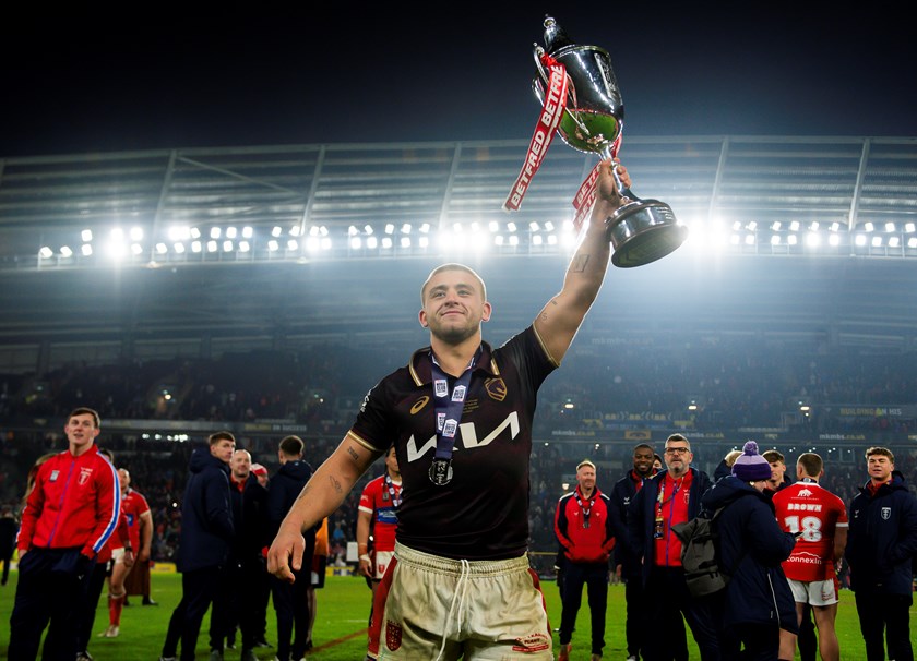 Hull KR playmaker Mikey Lewis, in a Broncos jersey, celebrates with the World Club Challenge trophy 